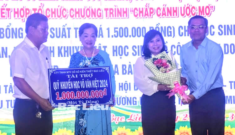 Phó Chủ tịch UBND tỉnh - Ngô Vũ Thăng (bìa phải) tặng hoa ghi nhận đóng góp của Công ty TNHH MTV Xổ số kiến thiết Bạc Liêu hỗ trợ Quỹ Khuyến học tỉnh 1 tỷ đồng
